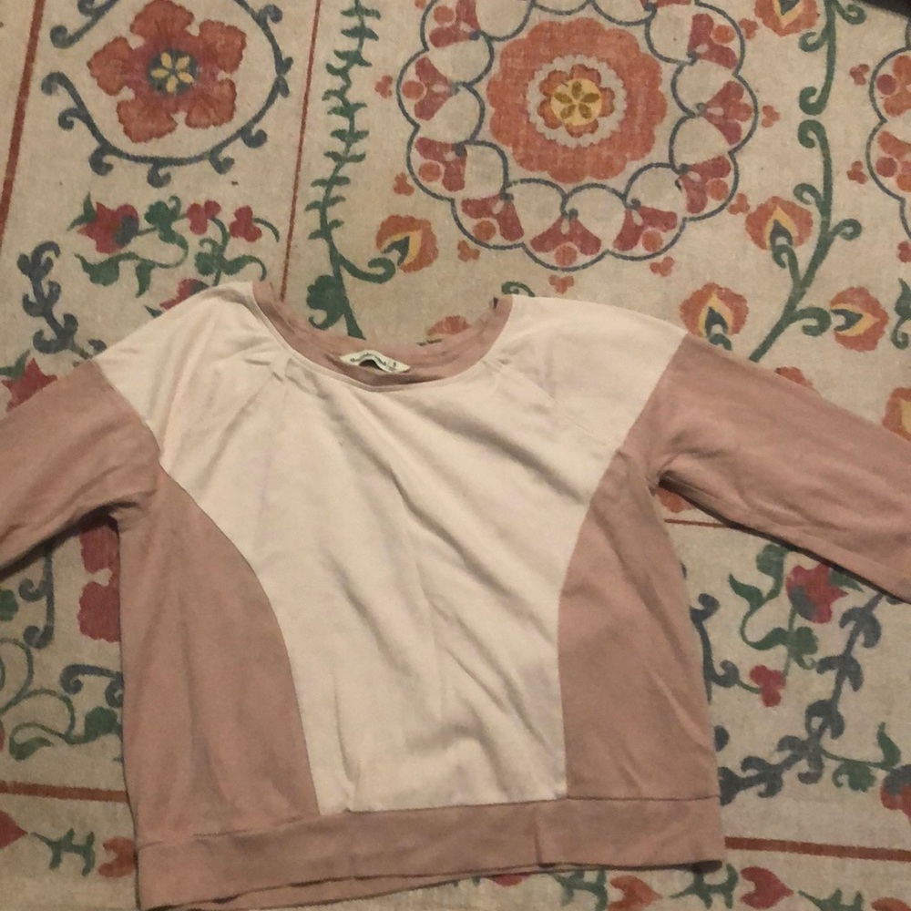 Pink crew neck sweater with light pink cutout.